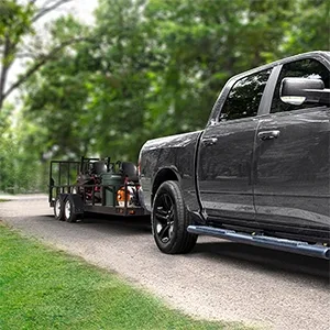 Pickup truck using a Reese trailer hitch to pull a small landscaping utility trailer