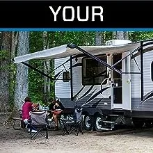 Family at campground outside RV trailer preparing lunch at picnic table