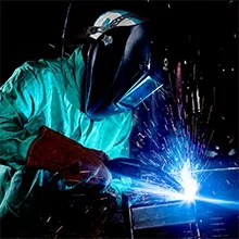 Person welding a Reese trailer hitch with sparks flying