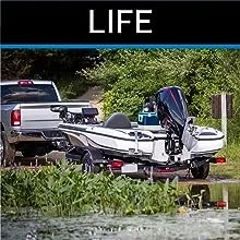 Pickup truck backing boat on trailer into lake from boat launch